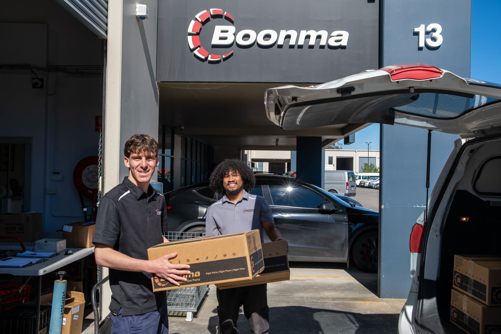 Sam and Romario loading boxed Boonma orders into a van at the Lansvale dispatch bay
