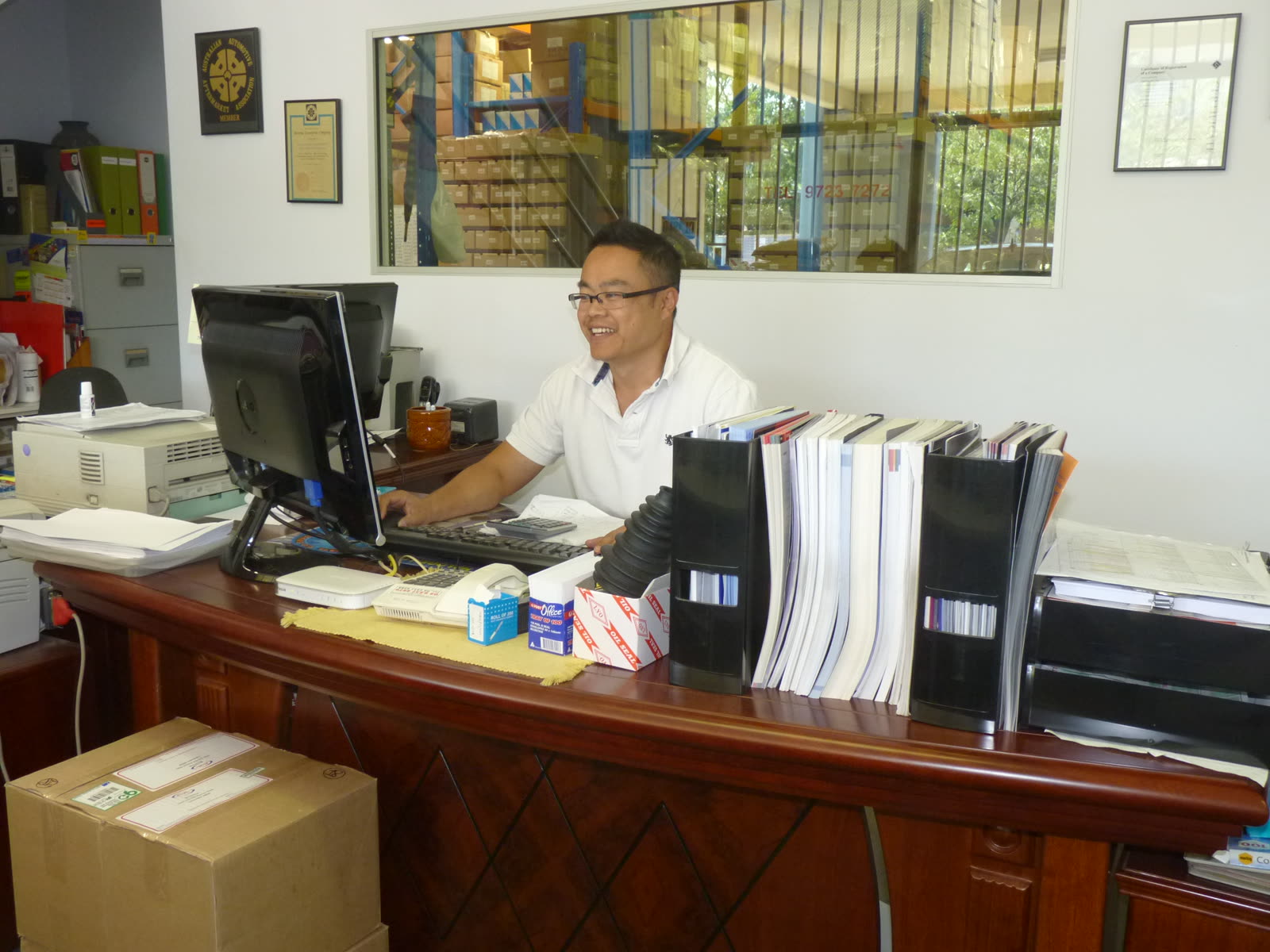 Vanh on the front desk in the early days, the warehouse racks behind the glass