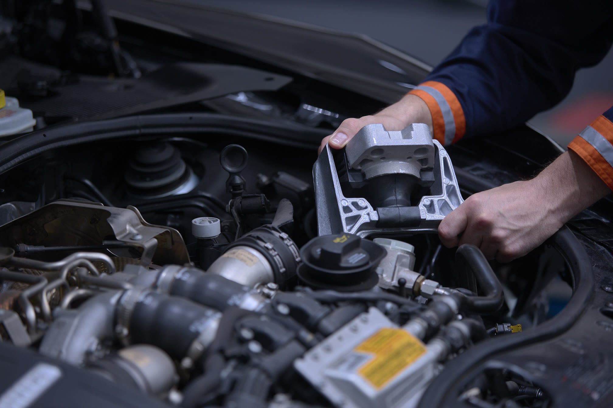 An engine mount being fitted in the engine bay
